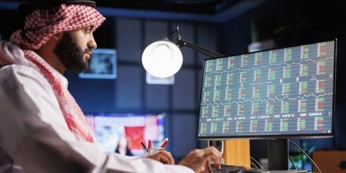 A professional Arab businessman works diligently at his desk engaged in online research and efficiently completing tasks. This Middle Eastern entrepreneur embodies dedication and the modern workplace.